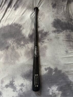 This is a black Louisville Slugger bat, model etched autographed